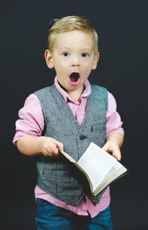 surprised boy with book in hand