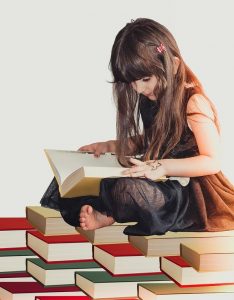 a girl sitting on books and reading