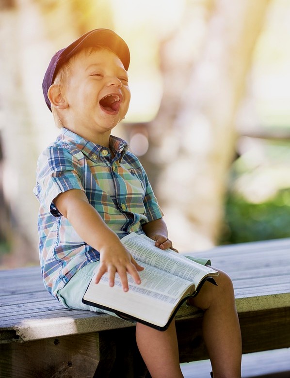 boy with book laughing