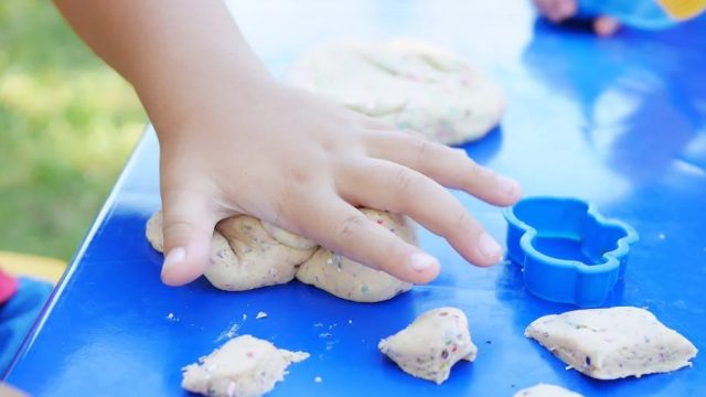 hand of a small child smashing play dough