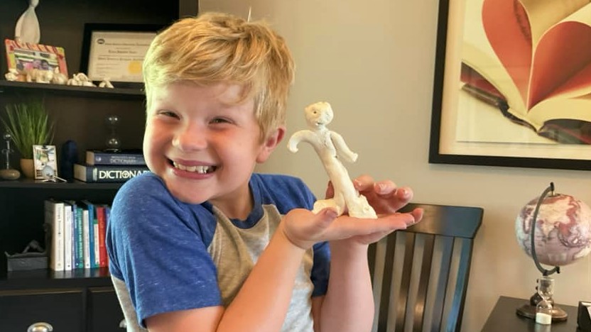 boy holding clay model