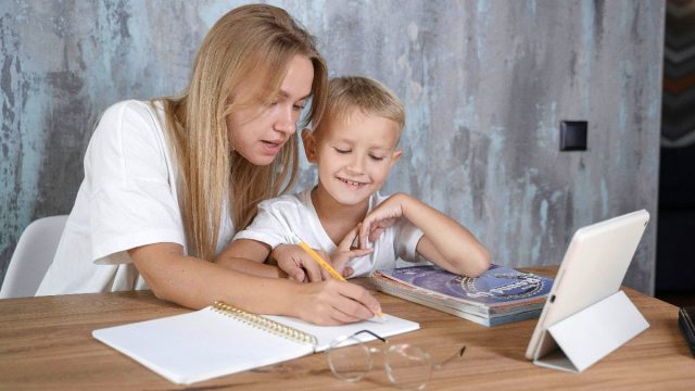 young woman helping child with school work