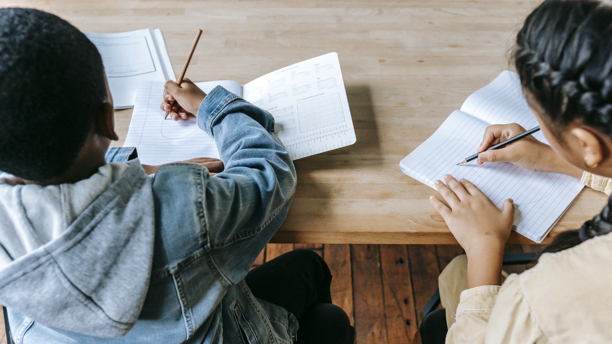 children at desk with notebooks